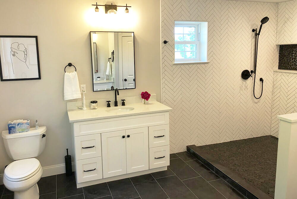 bathroom with single vanity and white tiled walk-in shower
