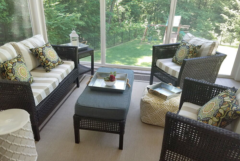 sunroom with large windows and wicker furniture