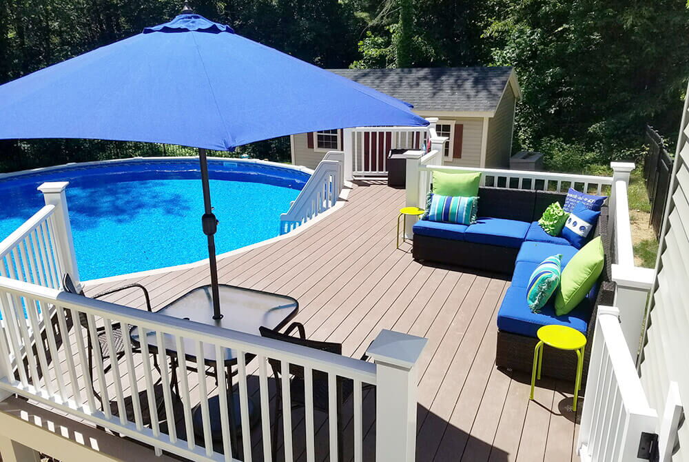 deck with outdoor furniture including couch and table adjacent to above ground pool