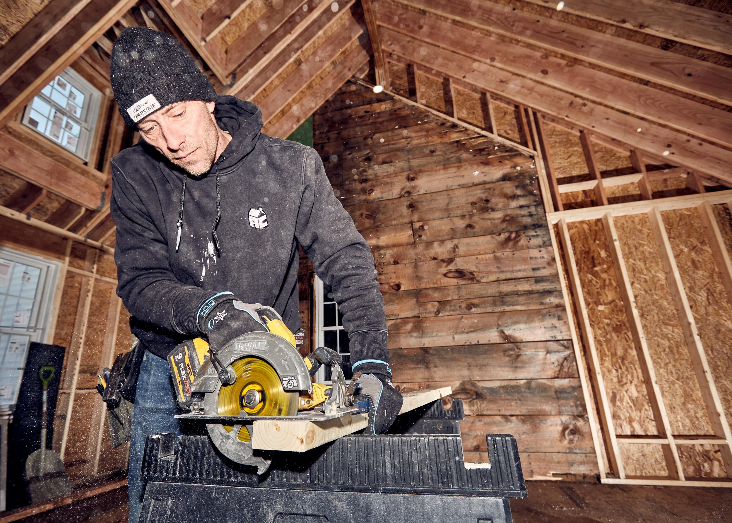 man using saw to cut 2 by 4