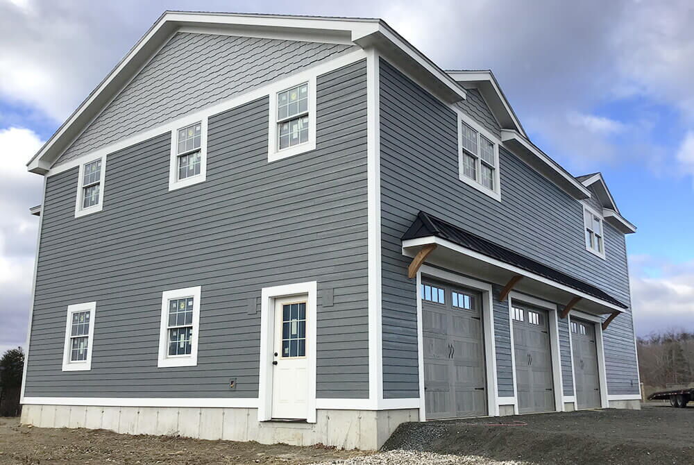 side view of two story detached garage with three garage bay doors